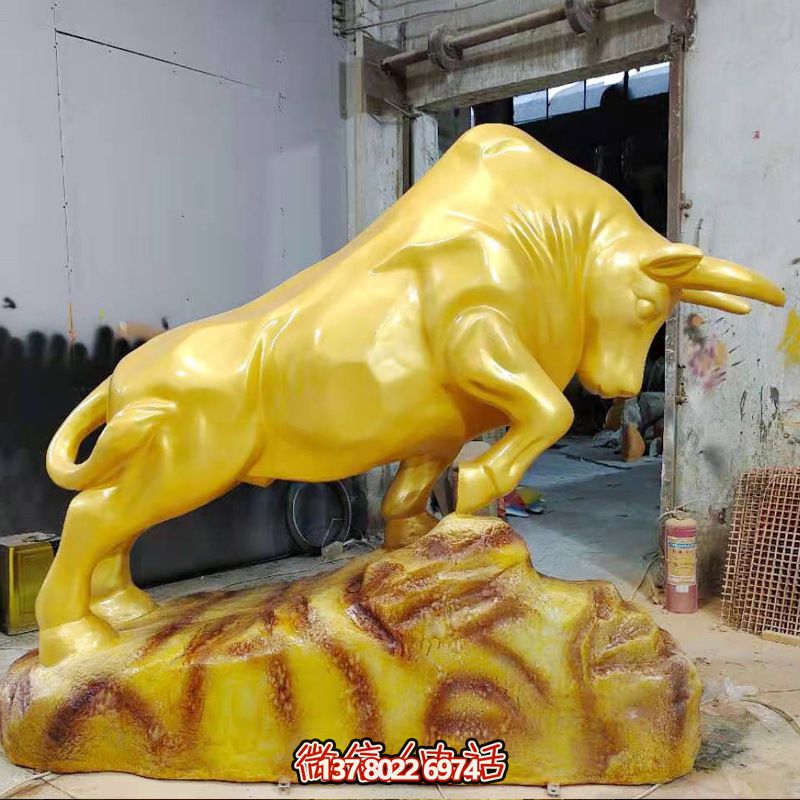 街道上摆放的金色的玻璃钢彩绘华尔街牛